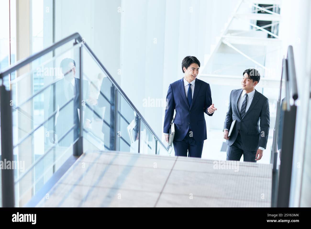 Two Businessmen In Suits Walking Up A Stairwell Stock Photo - Alamy