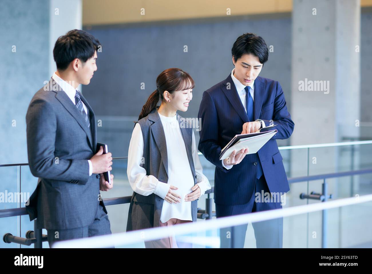 Three Business People Standing In An Office Building Stock Photo - Alamy