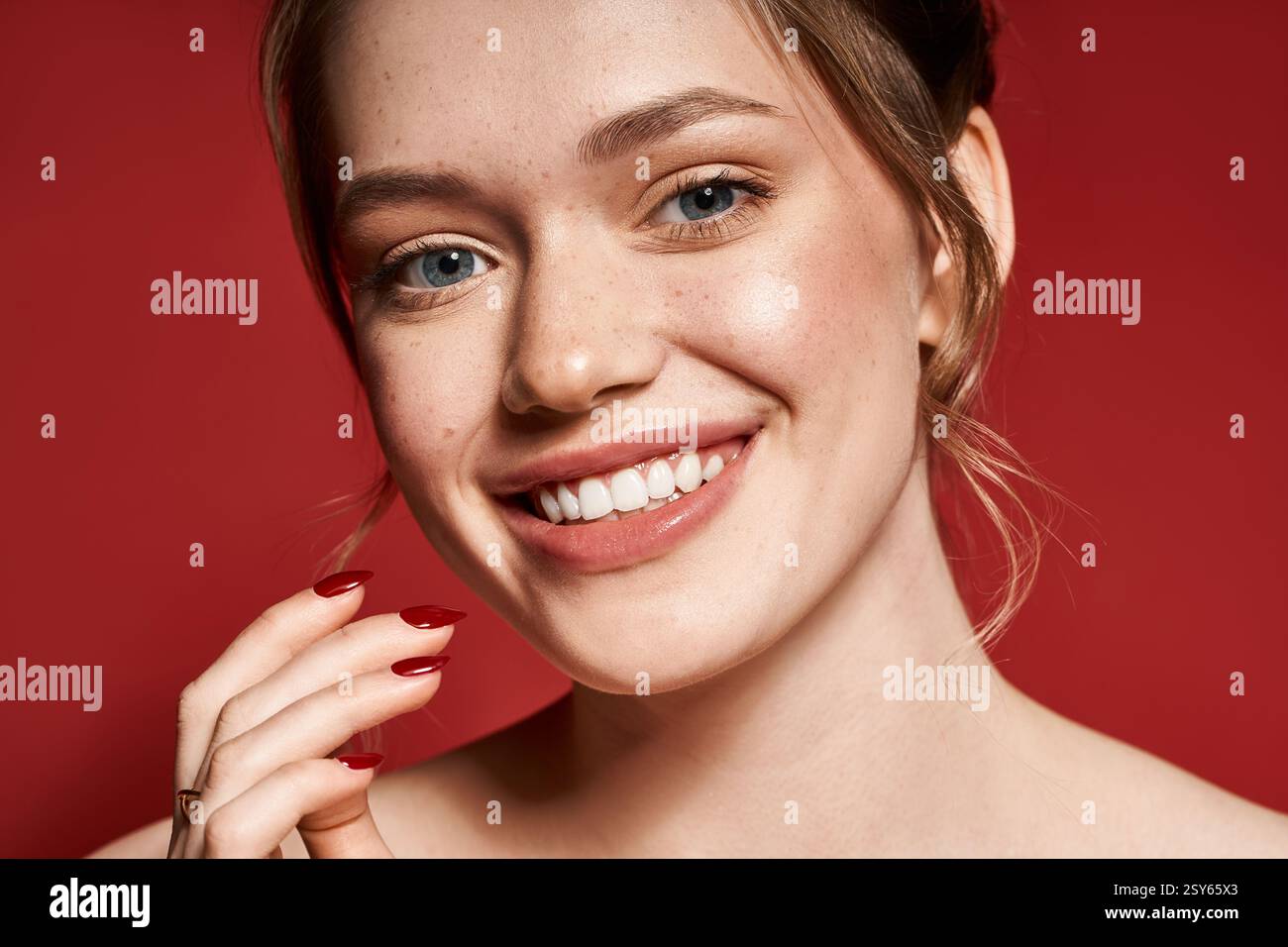 A young woman beams with style and trendy nails against a striking backdrop. Stock Photo