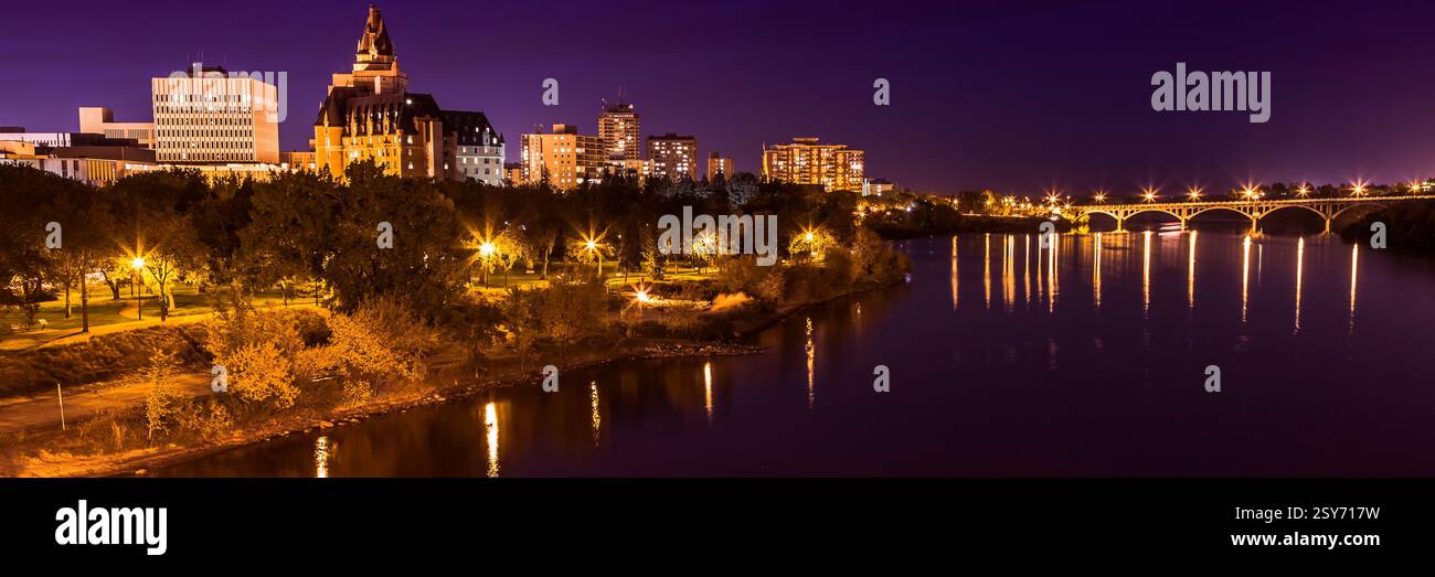 City at night with a river running through it. The river is lit up and the city is lit up as well Stock Photo