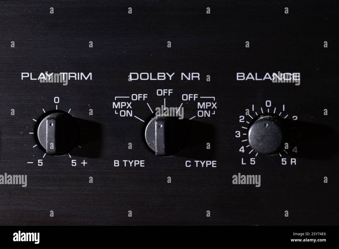 Close-up photograph of retro audio control panel showing knobs for playback settings and balance. Stock Photo