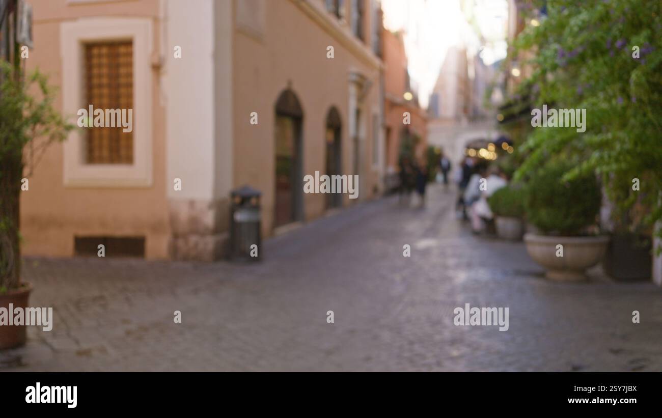 Blurred image of a street in rome with defocused people walking outside ...