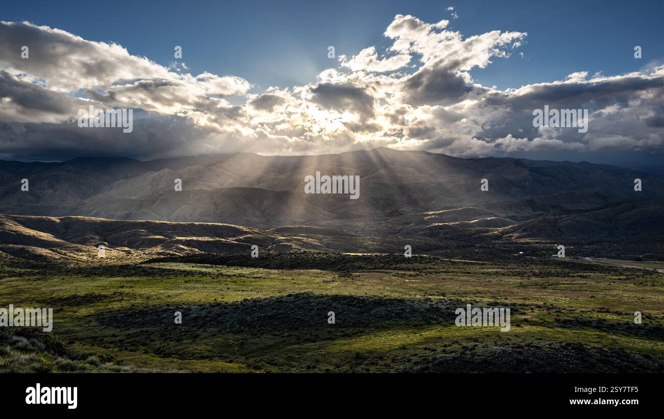 Sun Rays Piercing Clouds Over Green Field at on Veterans Highway in ...