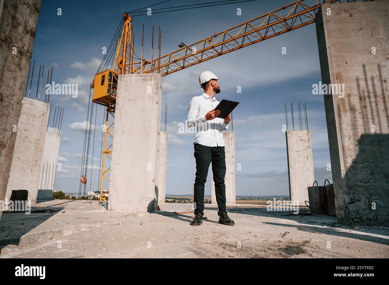 Inspector with notepad is standing on the construction site. Stock Photo