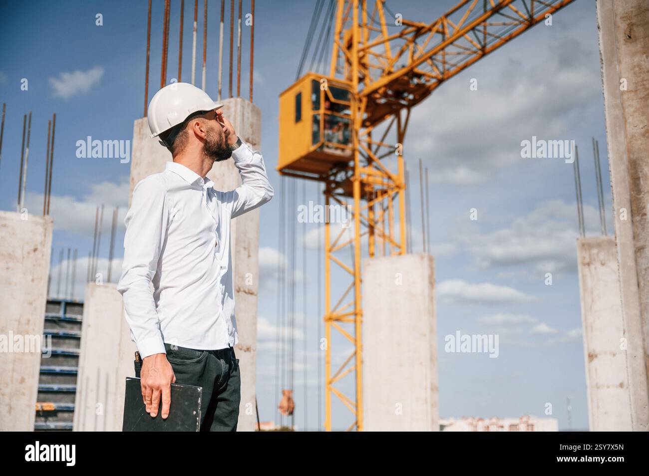Inspector with notepad is standing on the construction site. Stock Photo