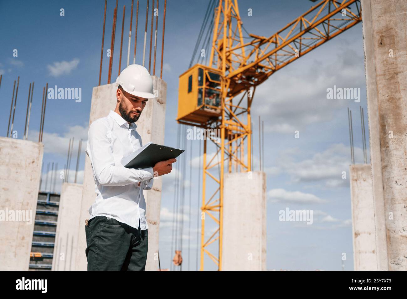 Inspector with notepad is standing on the construction site. Stock Photo