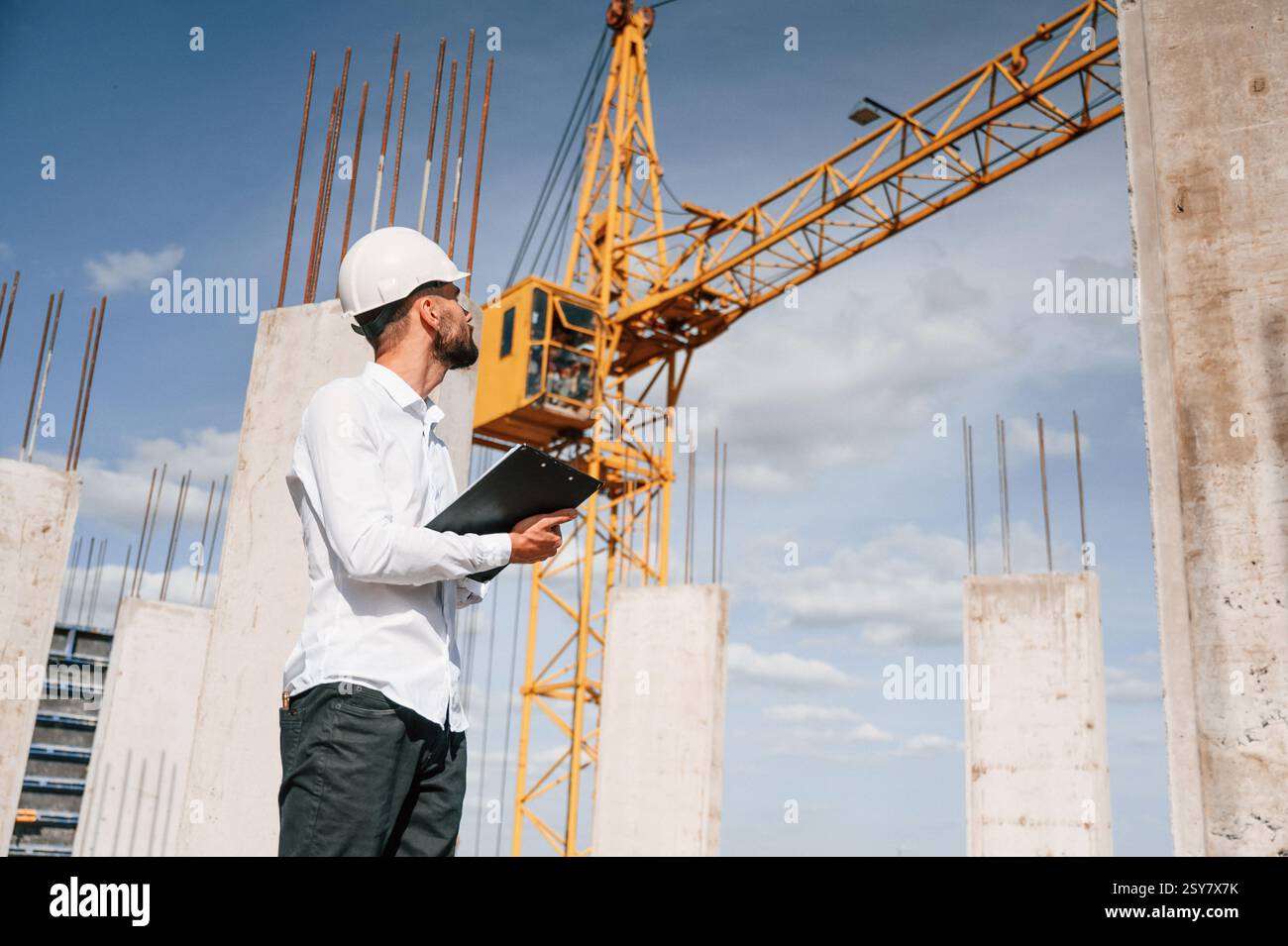 Inspector with notepad is standing on the construction site. Stock Photo
