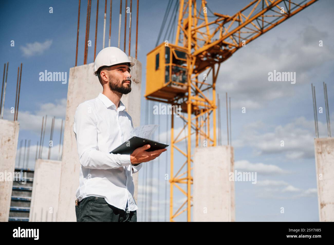 Inspector with notepad is standing on the construction site. Stock Photo