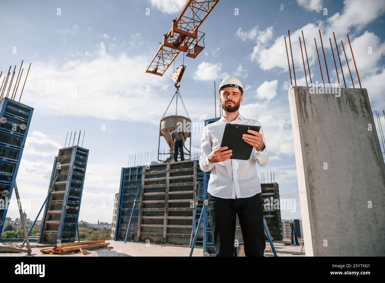 With notepad with documents. Foreman in uniform is working on the construction site. Stock Photo