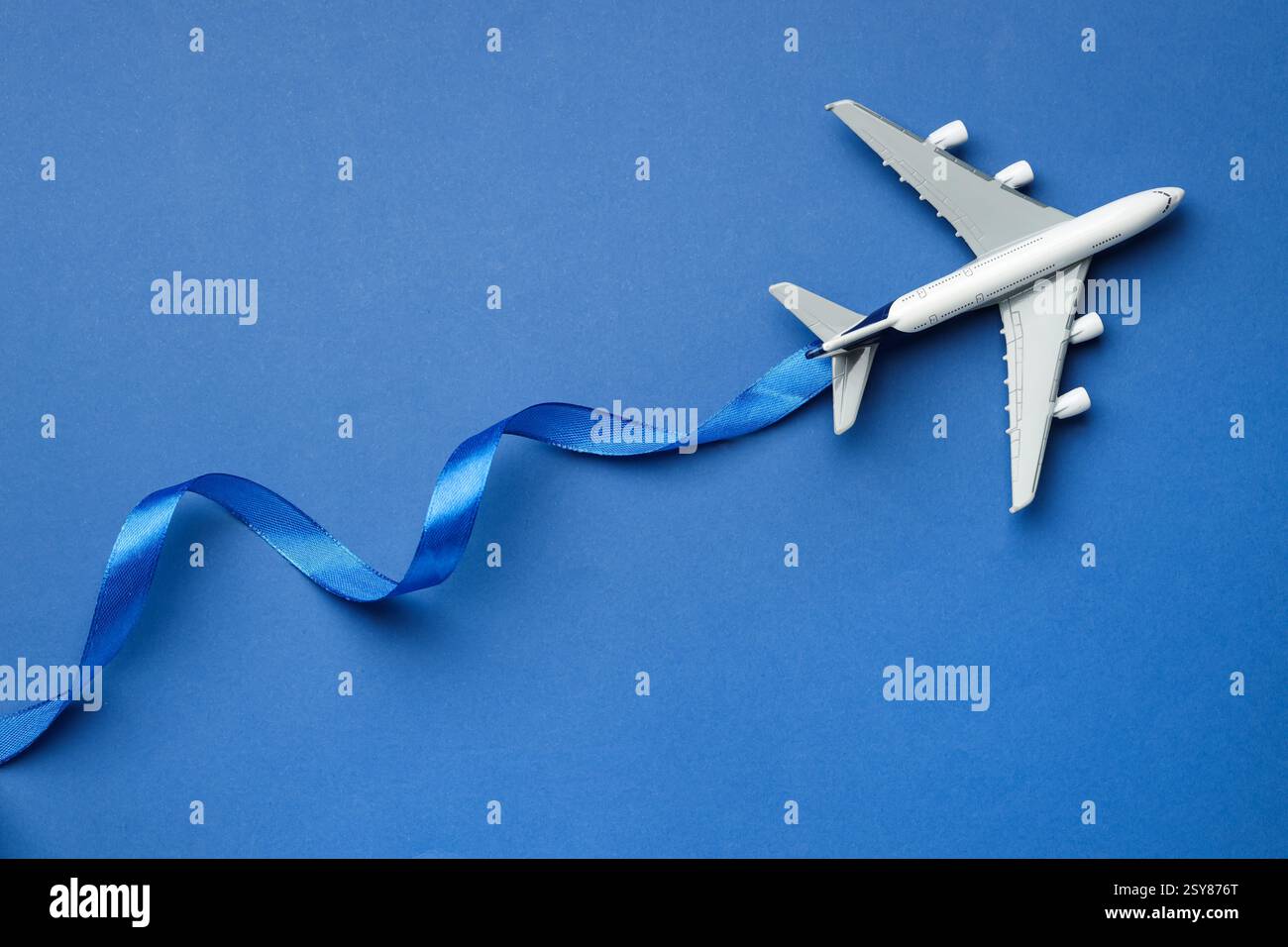 Flight Ribbon Graphic Plane model and ribbon as flight path on blue background, top view ...