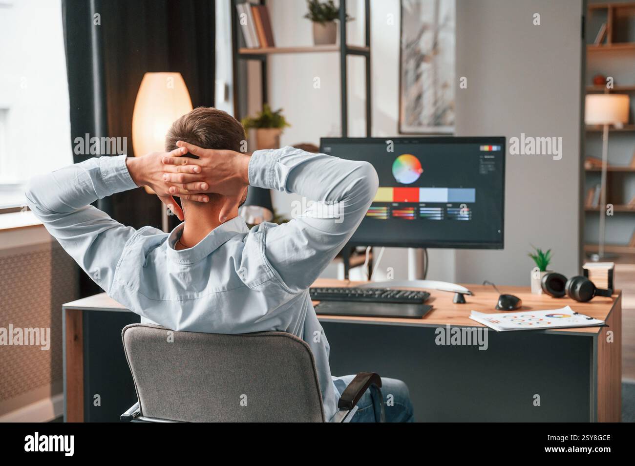 Designer is sitting by the computer and using graphics tablet with stylus. Stock Photo
