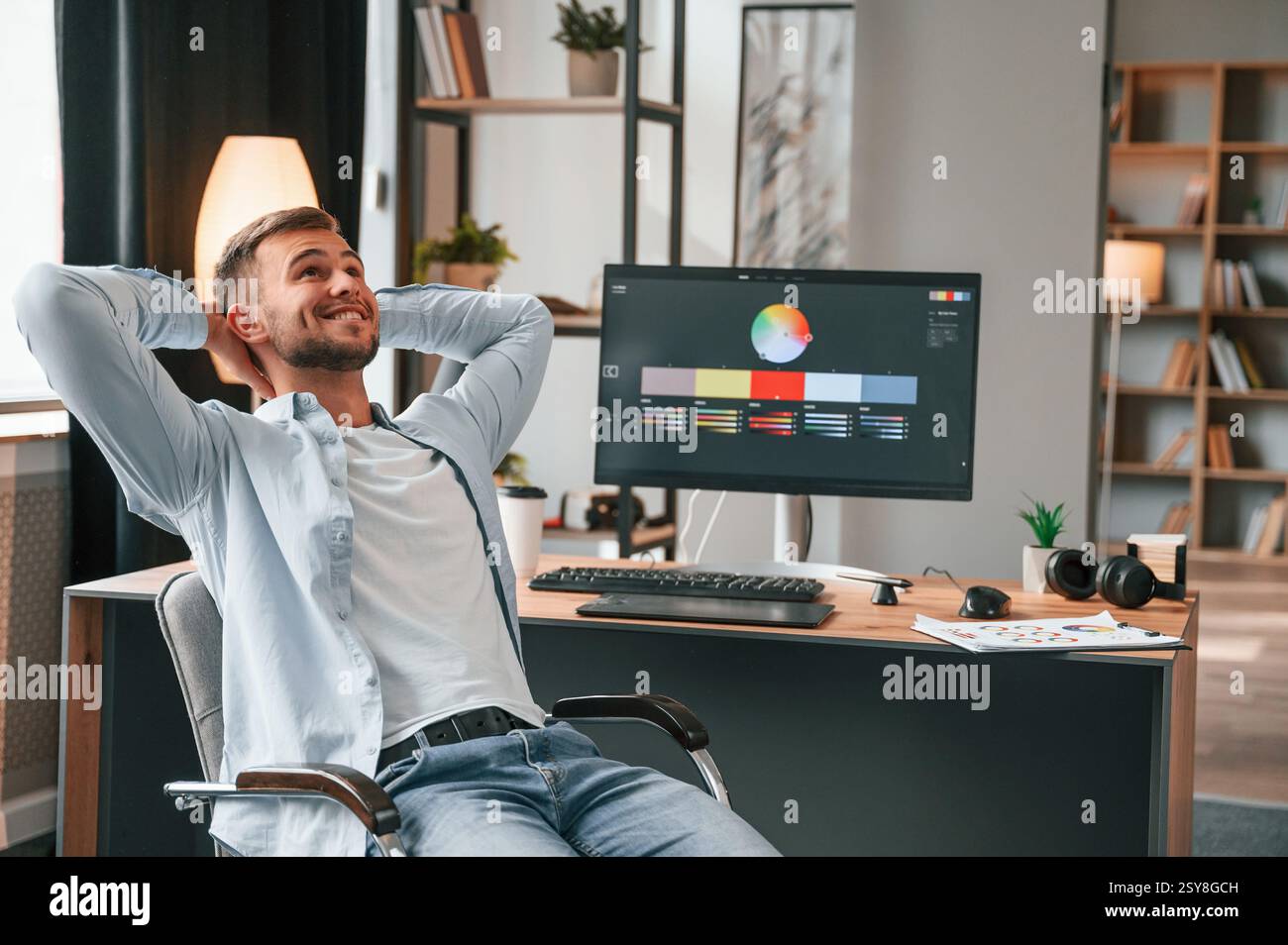 Designer is sitting by the computer and using graphics tablet with stylus. Stock Photo