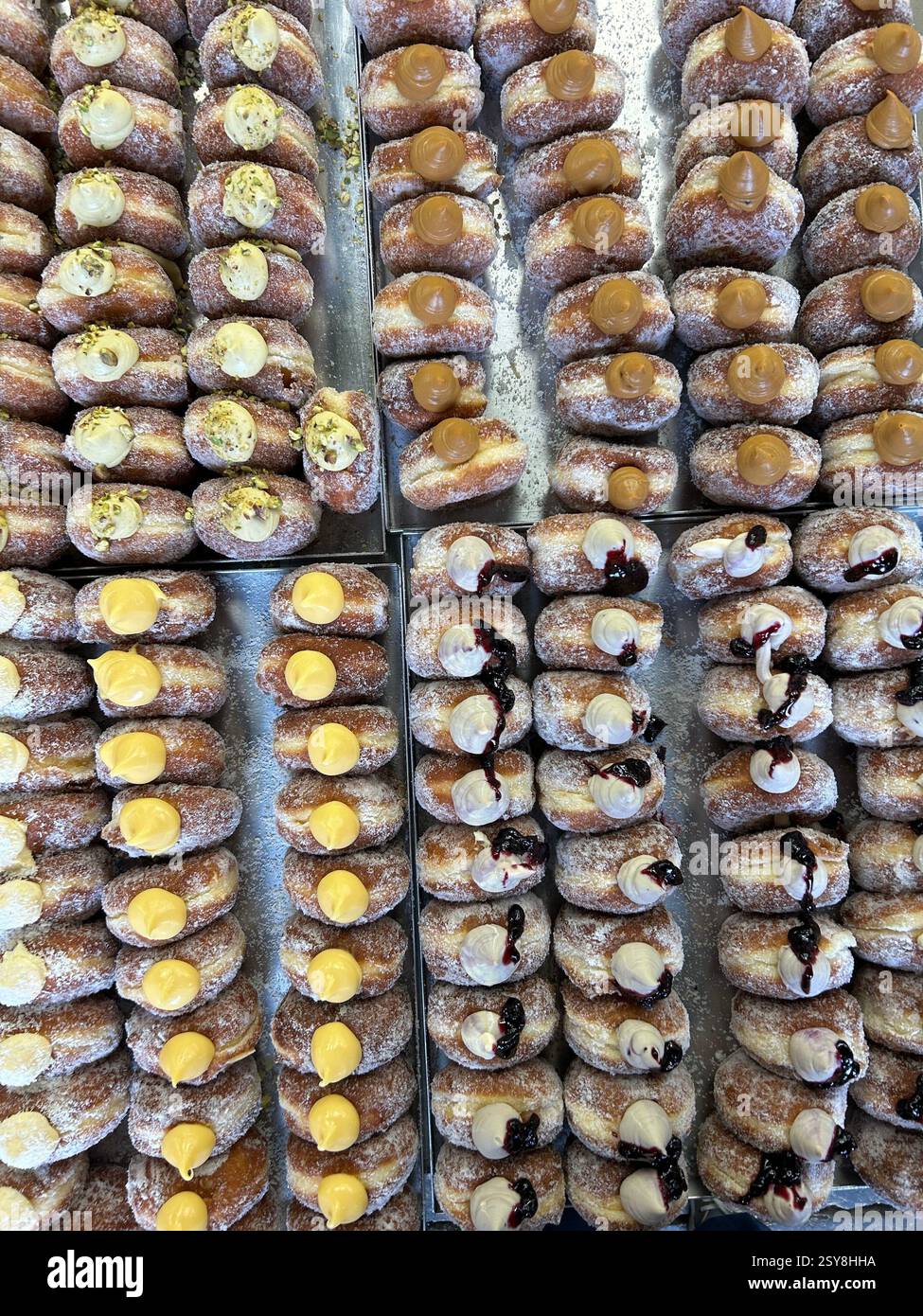 Aerial view of lots of different flavoured fresh doughnuts for sales at Bread Ahead store in Borough Market, London, UK - Smartphone Captured Stock Image