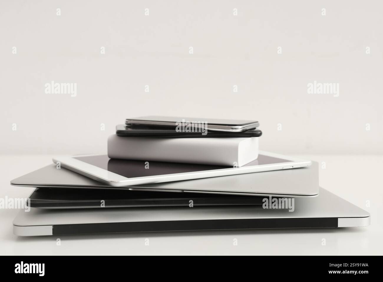 Stack of different modern gadgets on light background Stock Photo