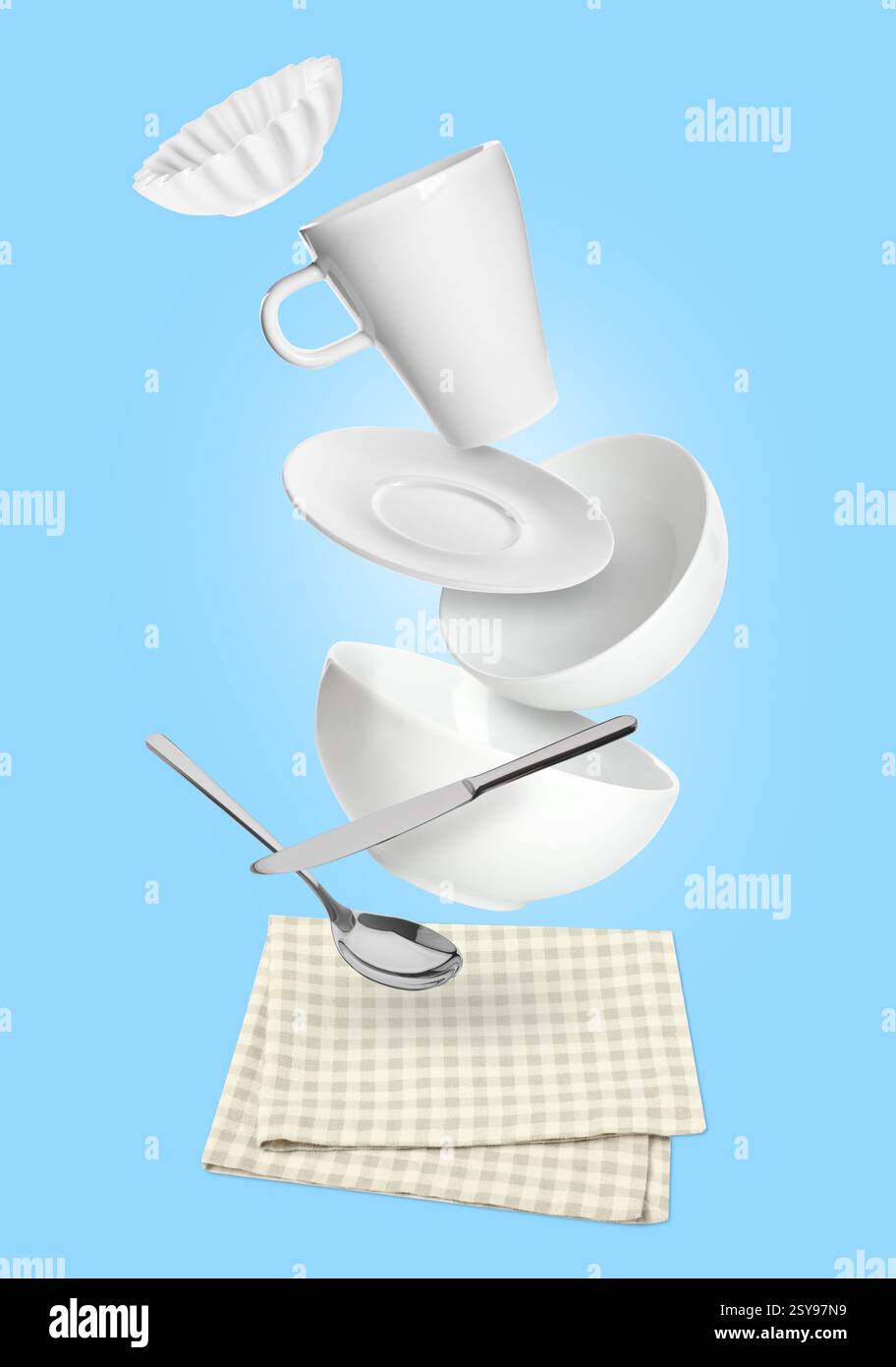 Clean dishware and silverware flying over checkered napkin on light blue background Stock Photo