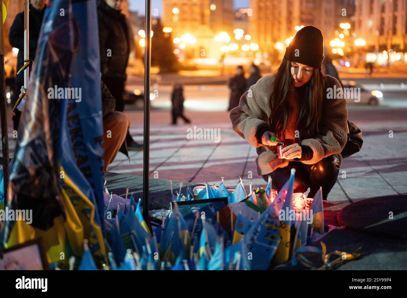 Non Exclusive: A woman lights a votive candle during the rally to mark ...