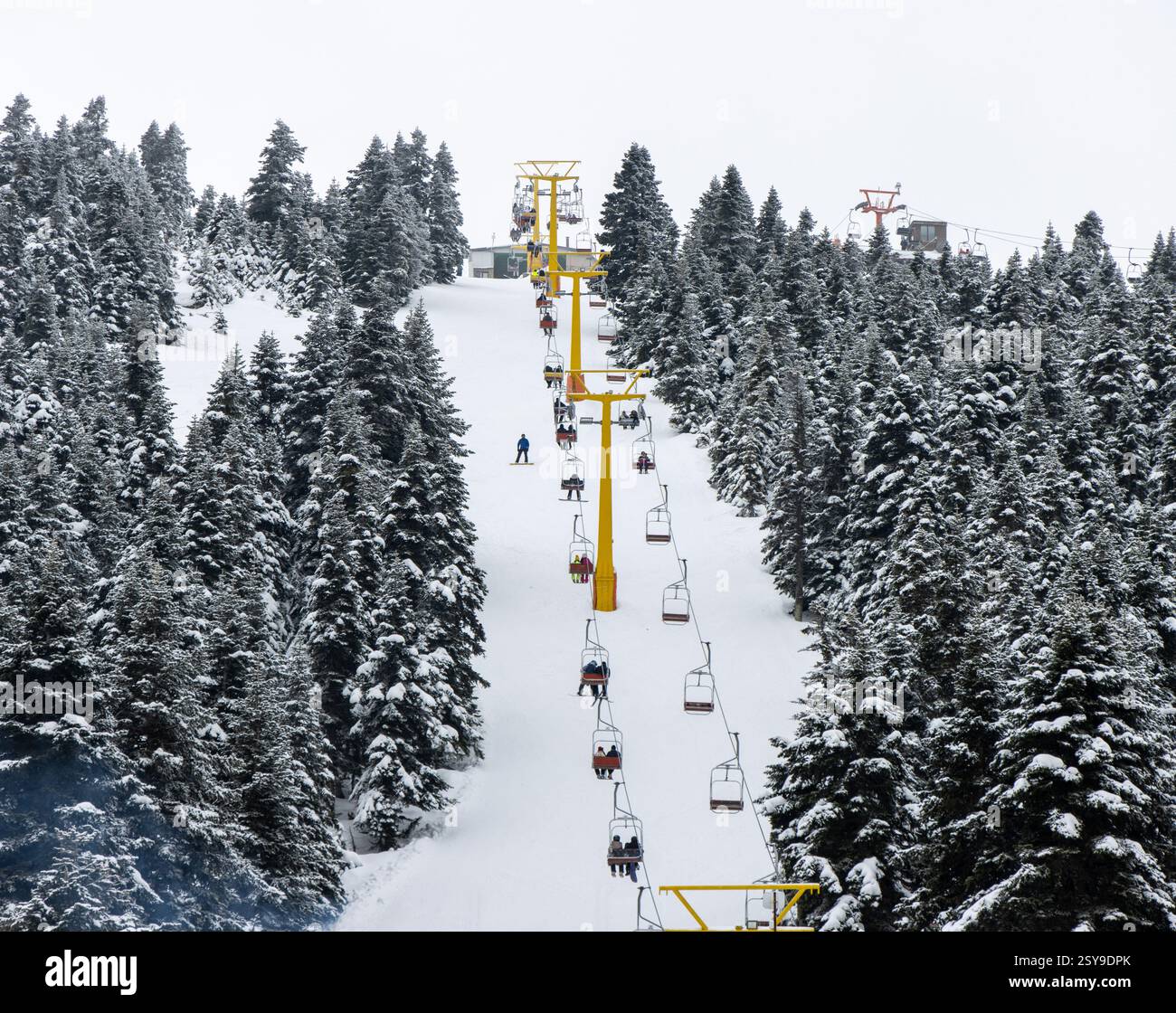 Peoples going out for skiing with chairlift in snowy winter mountain ski resort. Snow holiday concept Stock Photo