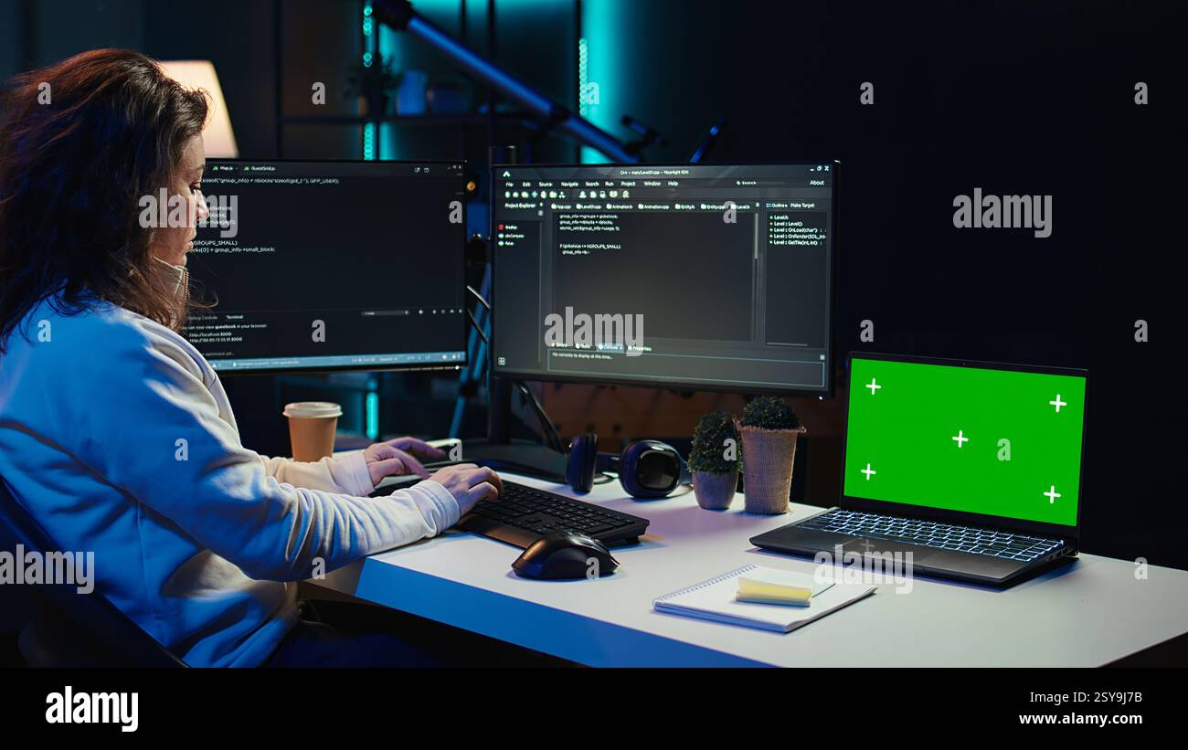 Programmer using green screen laptop to secure company servers from virus attacks. IT remote employee writing code, building firewalls protecting data using mockup notebook, camera B Stock Photo