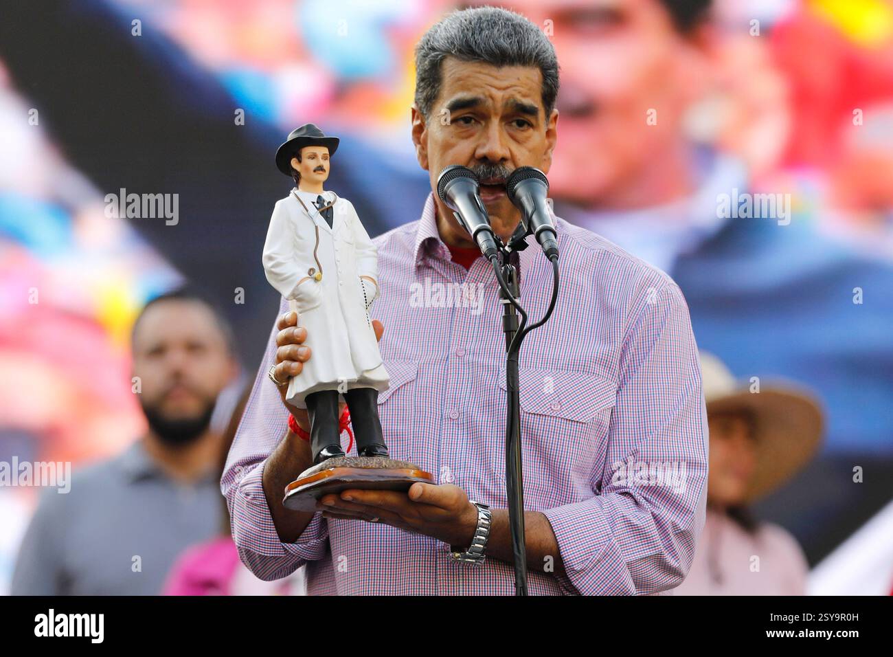 Venezuela's President Nicolás Maduro holds an image of Venezuelan Saint