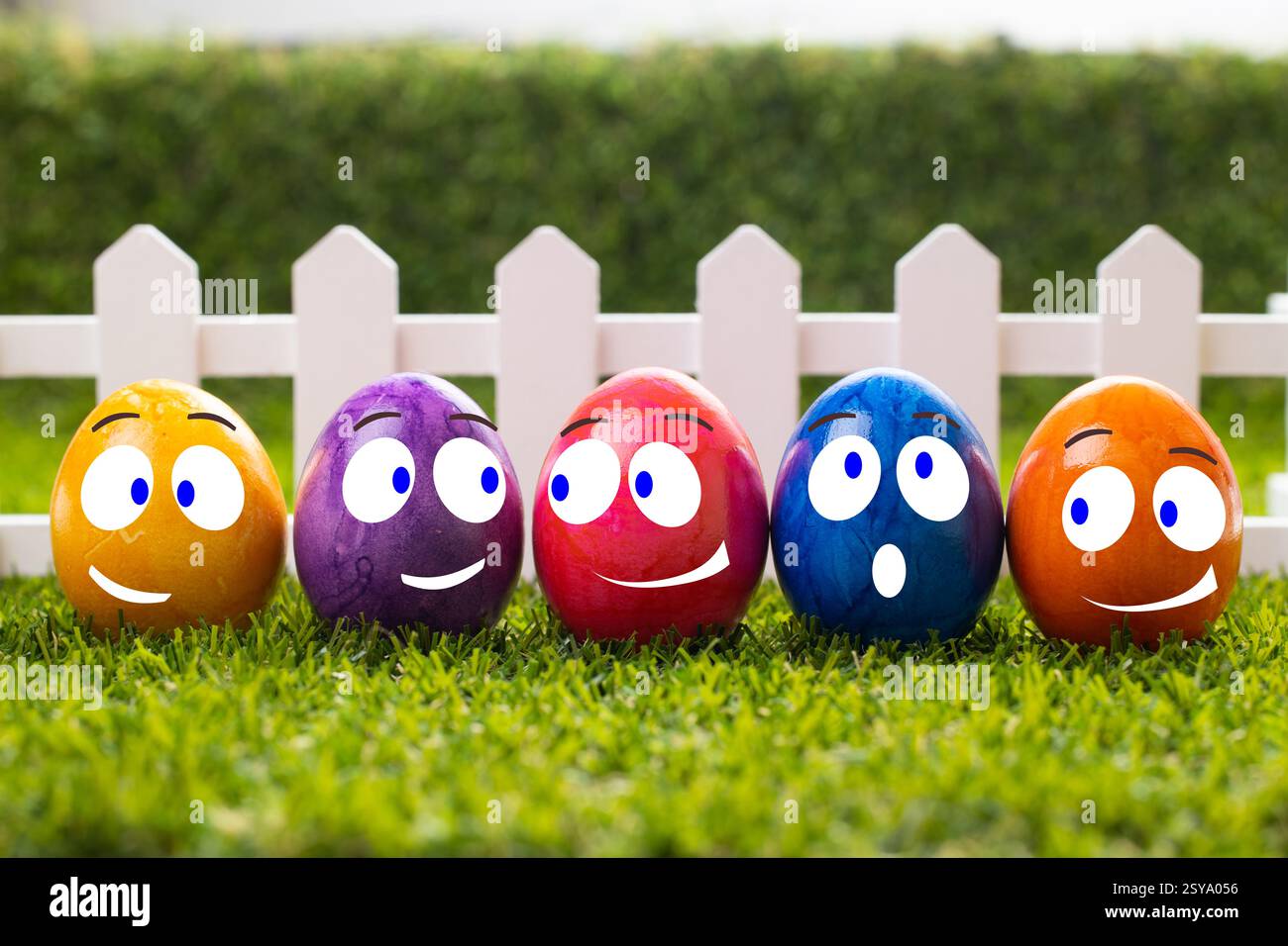 Multicolored Easter eggs stand in a row on a green lawn Stock Photo