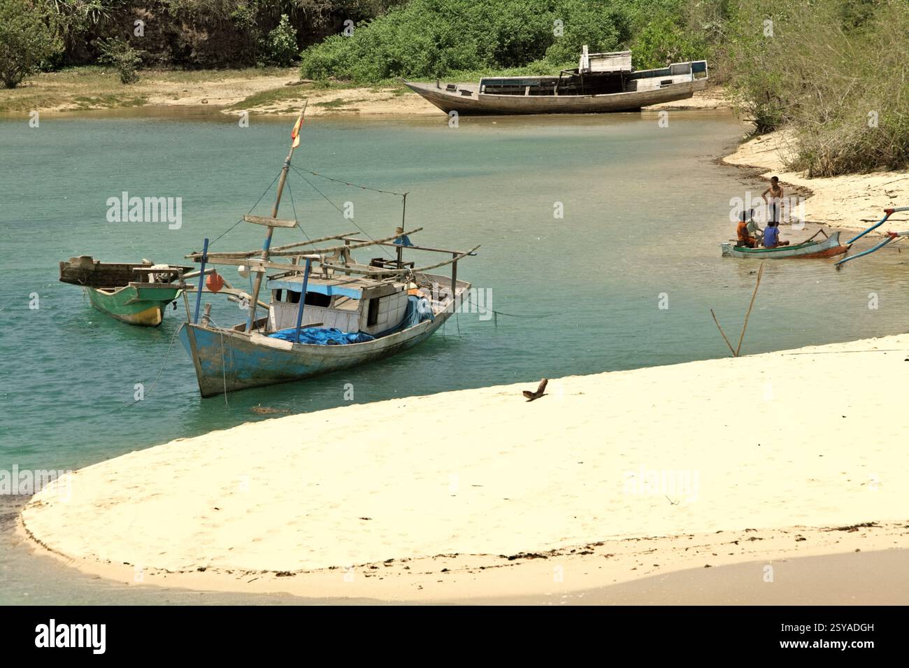 A sandy beach and fishing boats on a lagoon-like seascape in the fishing beach of Pero in Pero Batang villlage, Kodi, Southwest Sumba, Indonesia. Stock Photo
