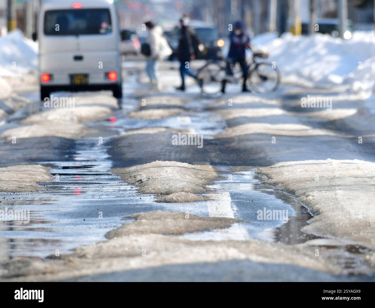 Road in bad condition as snow melts due to rising temperatures is seen ...