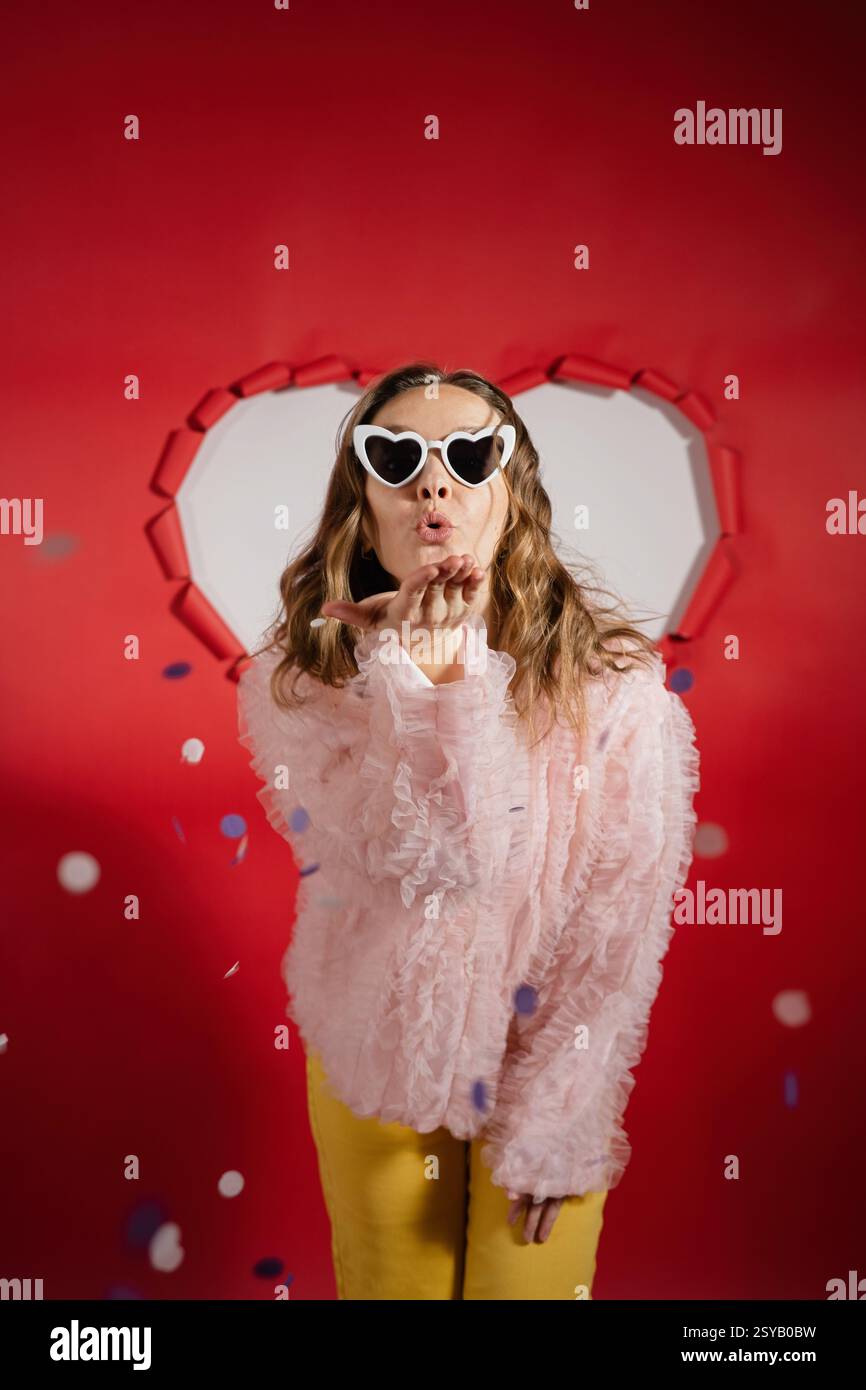 A charming woman with long hair wearing heart-shaped sunglasses and a ...