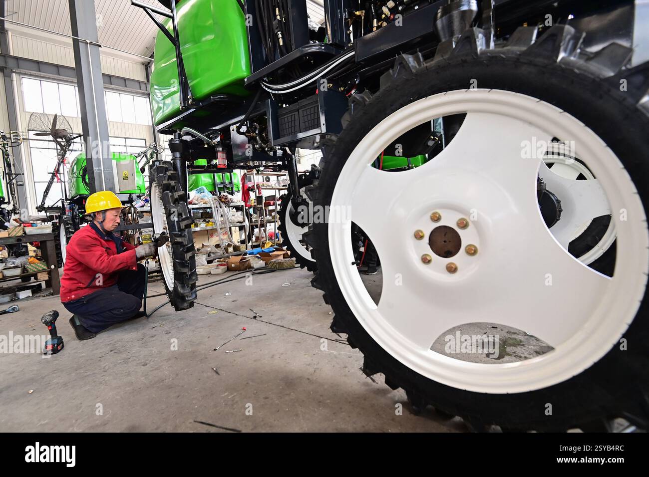 A worker assembles a plant protection machine at a workshop in Qingzhou ...