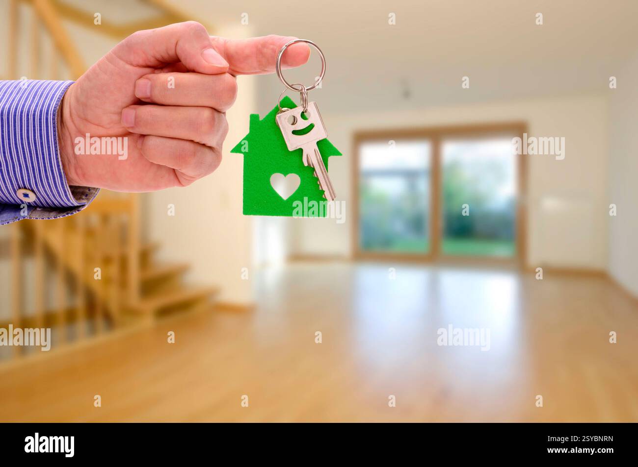 Immobilienangebor für eine Wohnung Vor einer leeren Wohnung hängt ein Wohnungsschlüssel als Angebot für Miete oder Kauf *** Real estate offer for an a Stock Photo