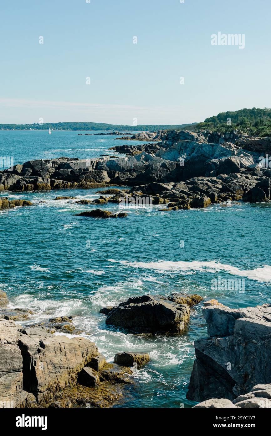 Rugged rocky coastline with blue ocean waves under a clear sky Stock ...