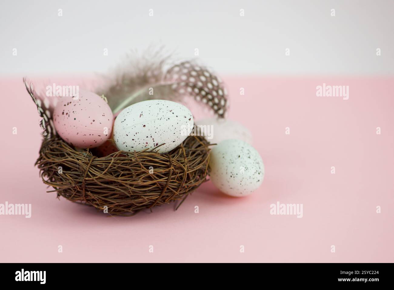 Easter eggs in a basket with willow on a pink background Stock Photo