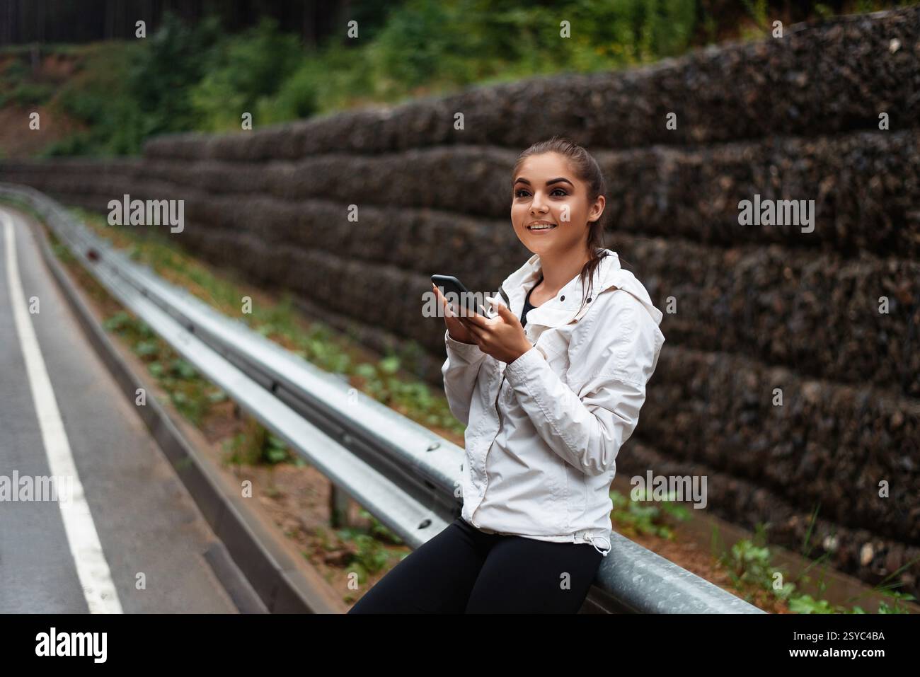 Smiling female tourist using modern cell phone outdoors Stock Photo