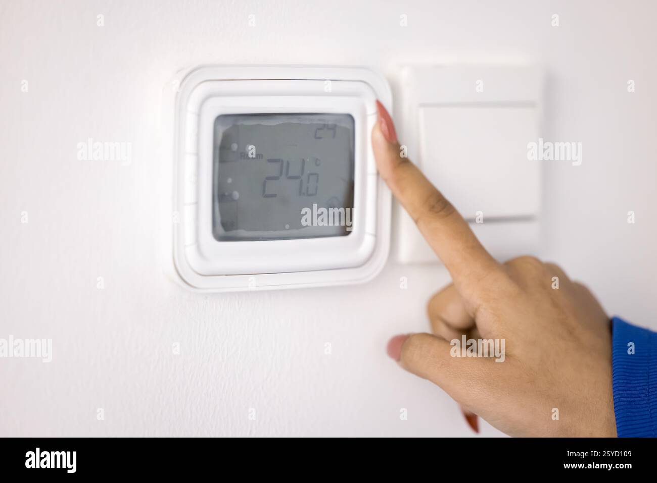 Female hand adjusting temperature on digital thermostat Stock Photo - Alamy