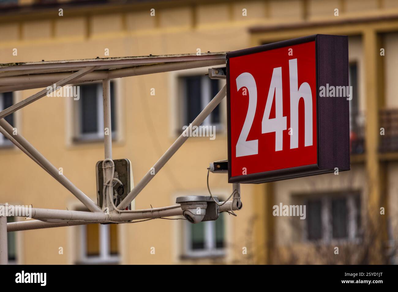 Red illuminated sign with the inscription 24, 24-hour alcohol store, open 24 hours a day, seven days a week Stock Photo
