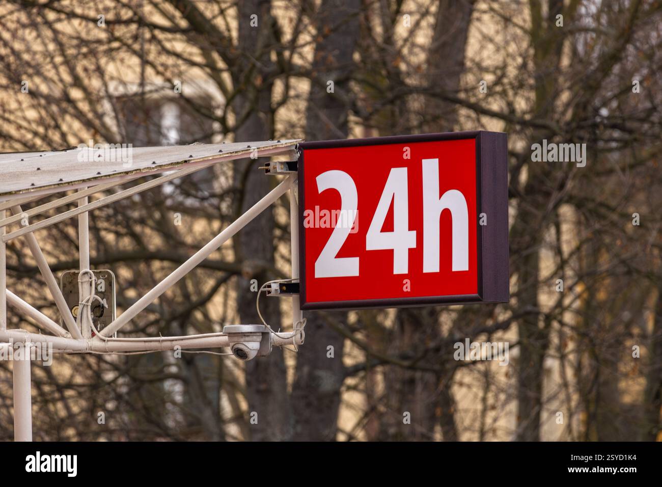 Red illuminated sign with the inscription 24, 24-hour alcohol store, open 24 hours a day, seven days a week Stock Photo