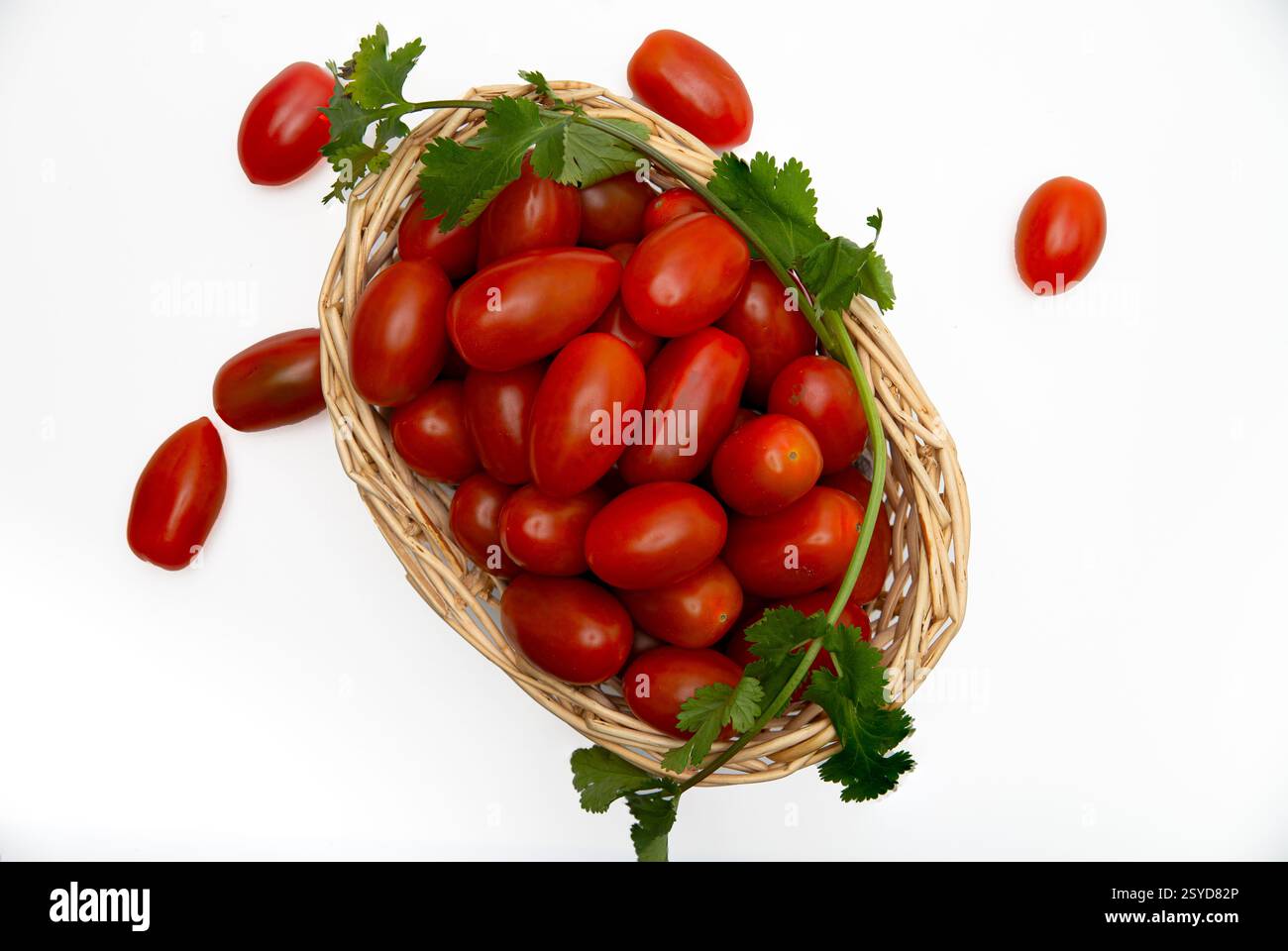 Cherry Tomatoes in a wicker basquet on white background. Stock Photo