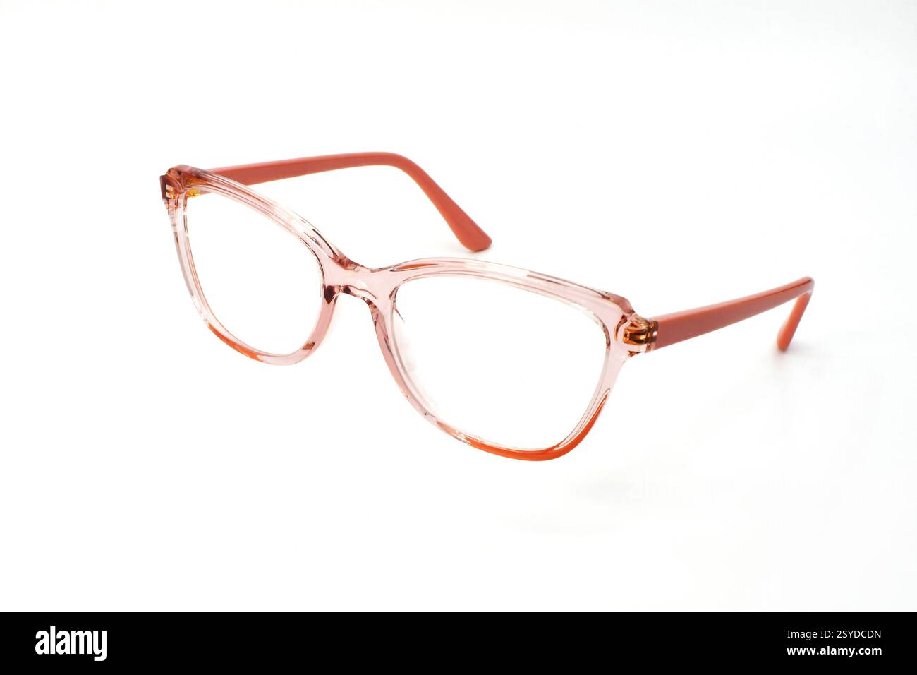 Pair of women's glasses with transparent pink frames isolated on a plain white background. Eye health concept. Copy space. Stock Photo
