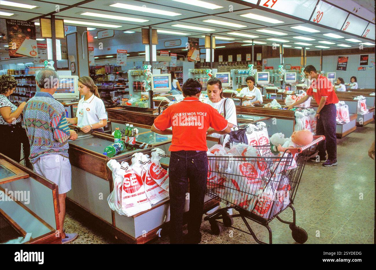 Brazil, Sao Paulo. Paying at the cash register in a supermarket with ...