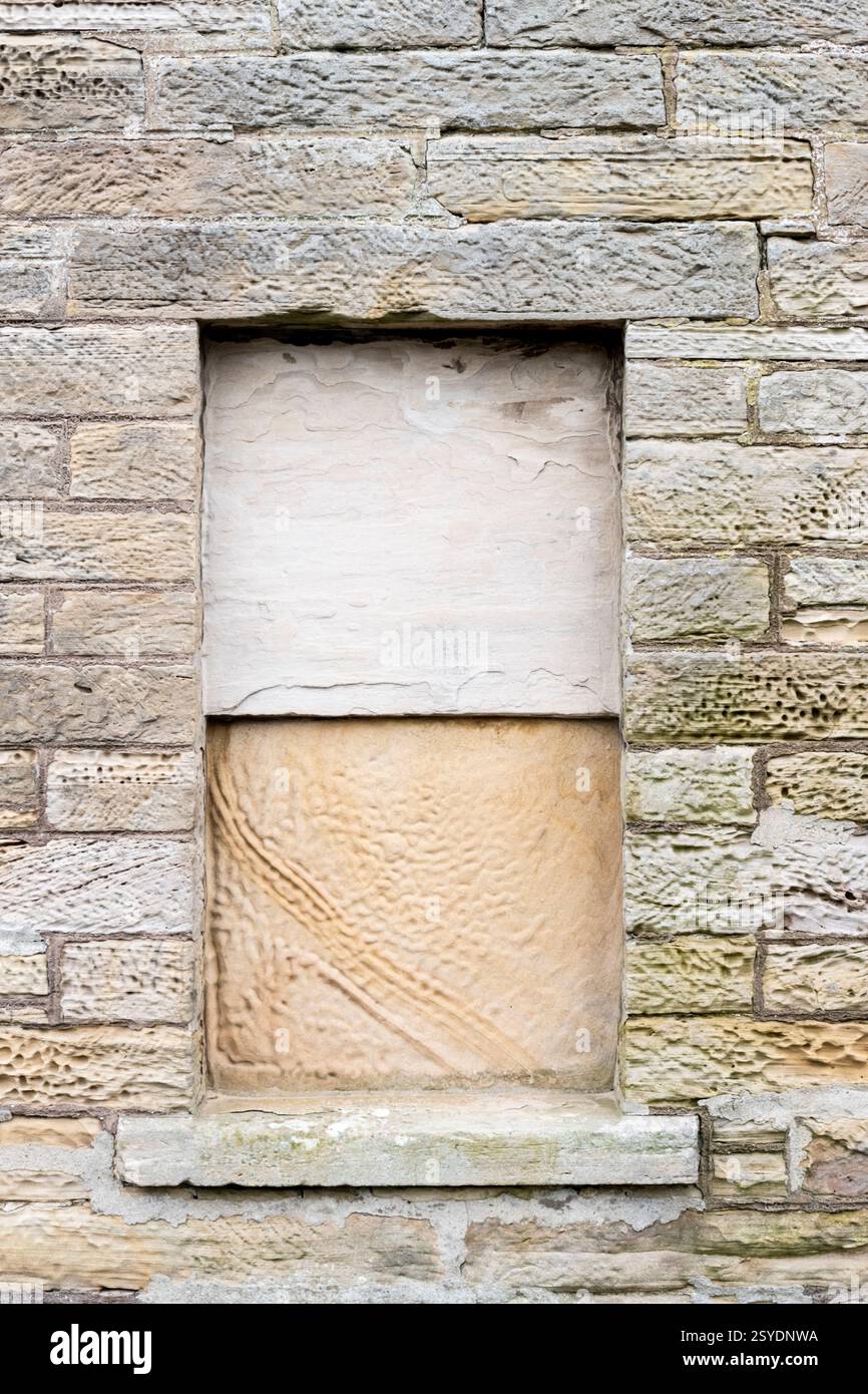 Window in old house sealed up with stone slabs. Stock Photo
