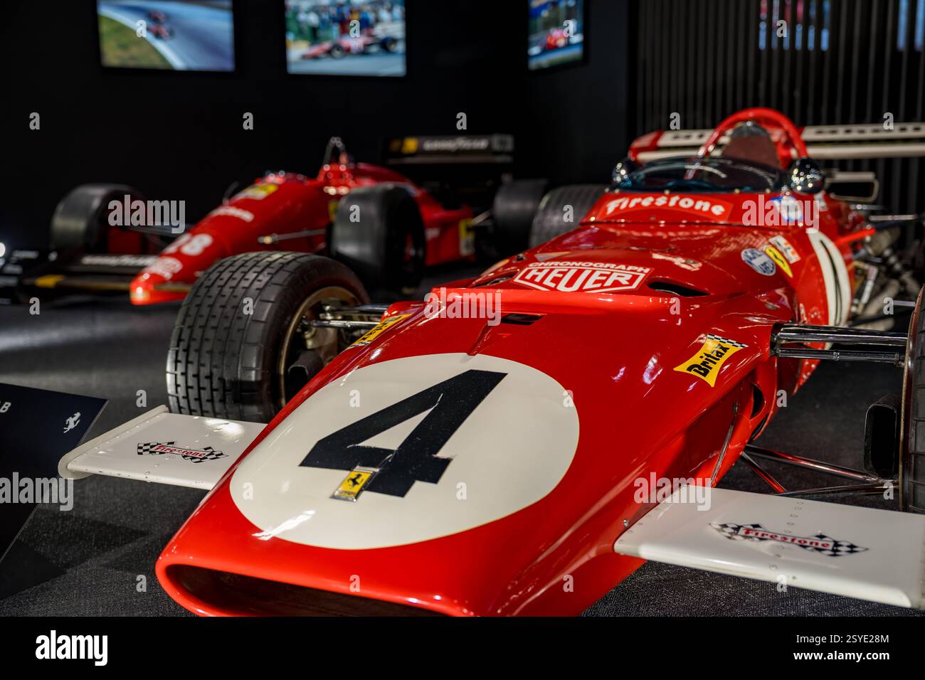 Classic red race cars on display at an automotive exhibition capturing ...