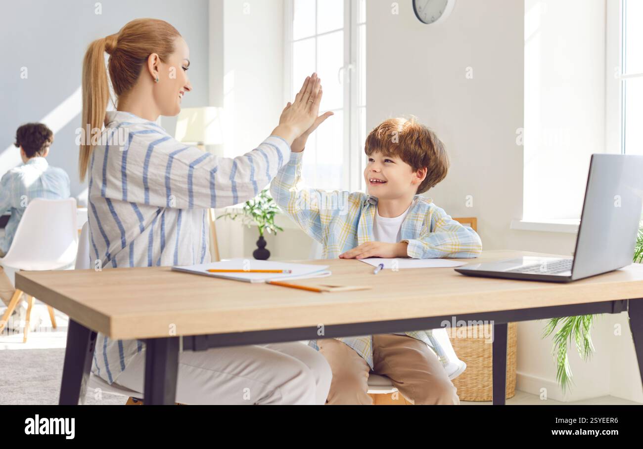 Mother Helps Son With Homework And Giving High Five Stock Photo