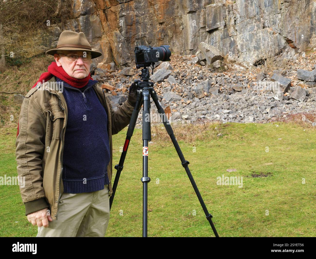 Feb 2025 - Mature landscape photographer with his camera on a tripod ...