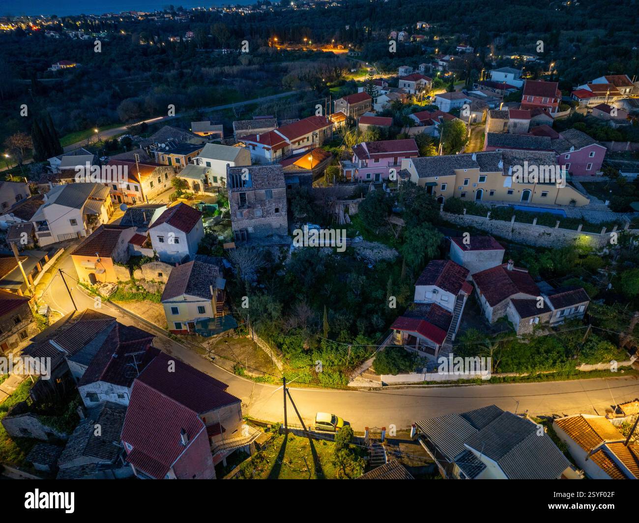 Aerial view captures a European village nestled among trees, lit by ...