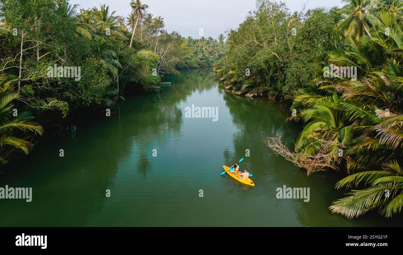 Paddlers navigate tranquil waters surrounded by lush greenery and palm ...
