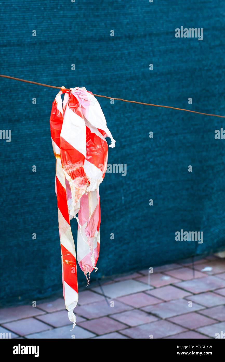 A vibrant red and white flag is gracefully hanging down from a wire ...