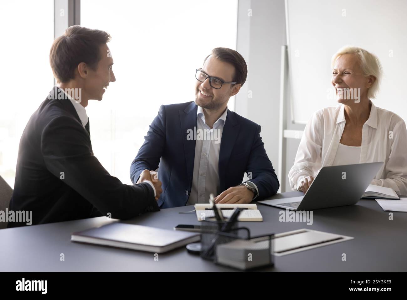 Two hr managers recruit applicant confirm successful placement with handshaking Stock Photo
