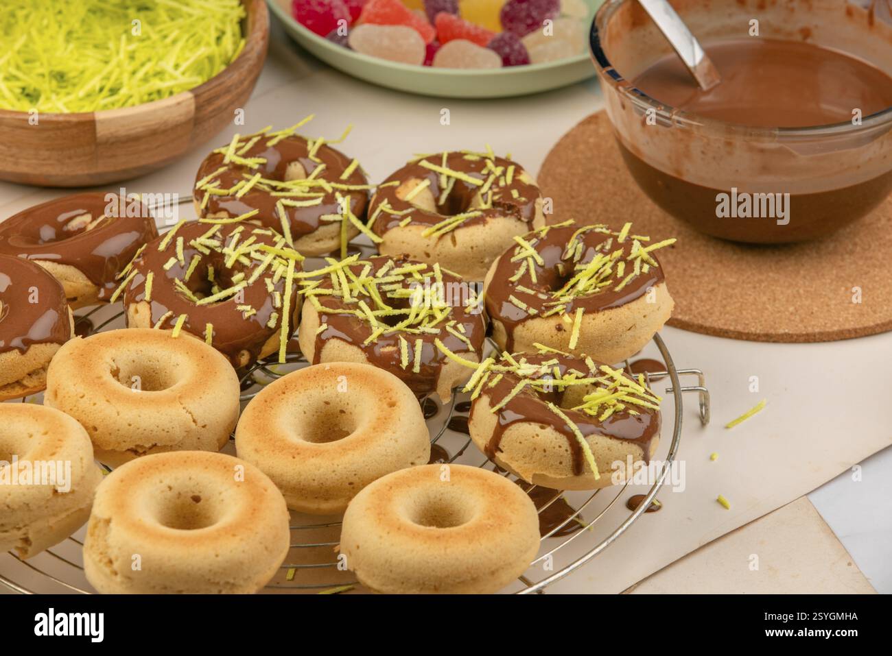 Partially glazed donuts with sprinkles on a rack Stock Photo - Alamy