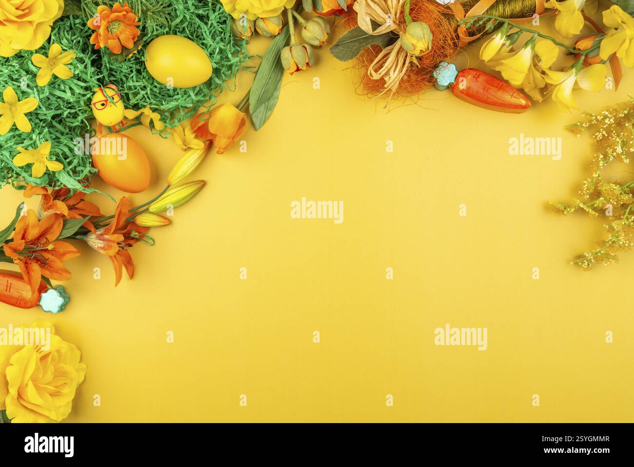 Yellow background with natural decorations such as flowers, Easter eggs and carrots Stock Photo