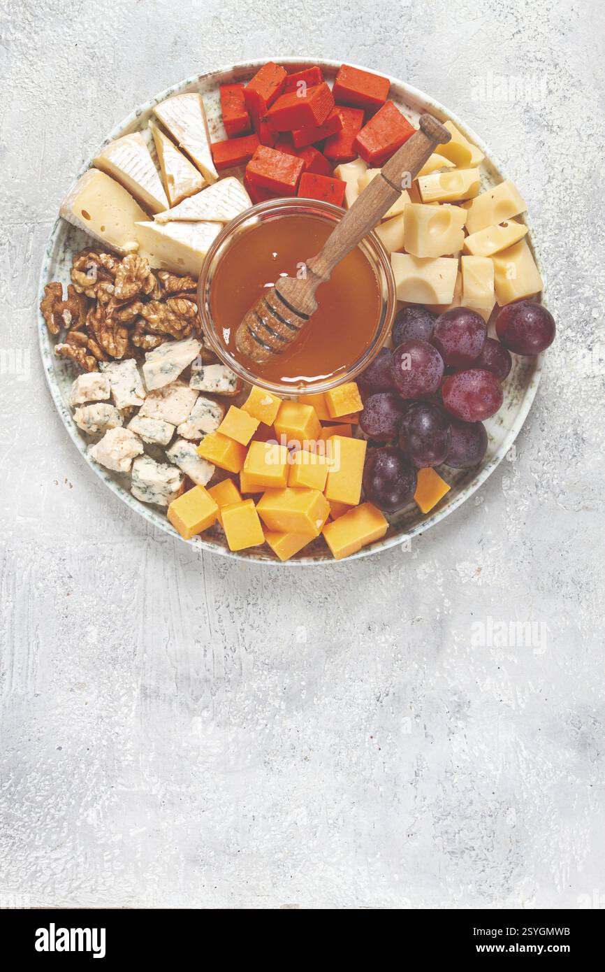 Appetizer, assorted cheese, with nuts and honey, on a round plate, top view, no people Stock Photo