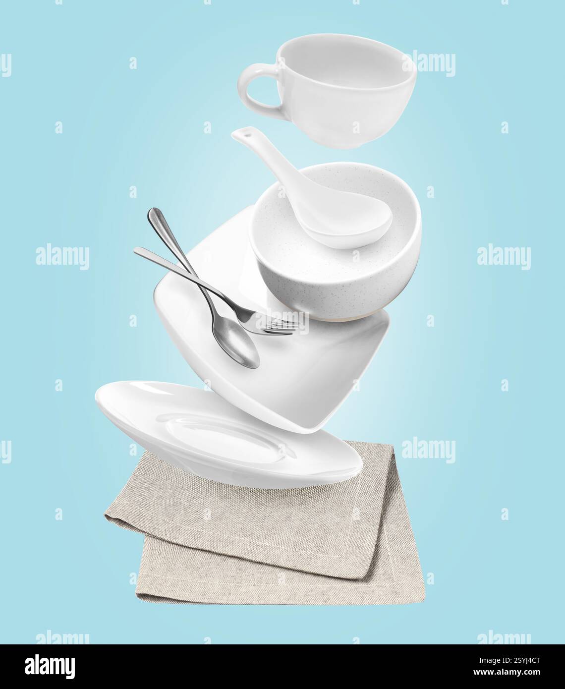 Clean dishware and silverware flying over napkin on light blue background Stock Photo